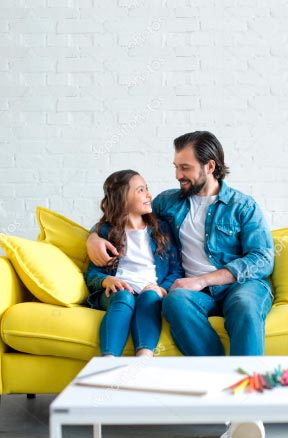 Padre e hija convesando en el sofá