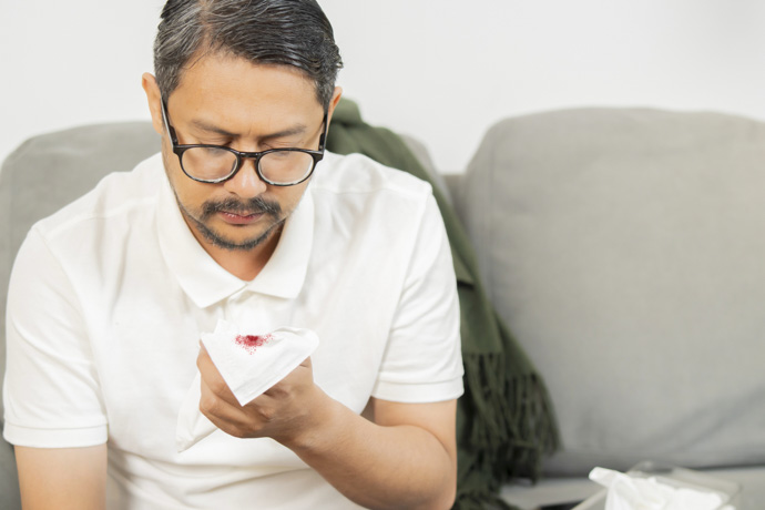 Hombre tosiendo sangre