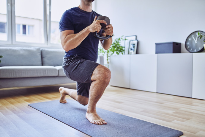 Hombre practica zancadas con pesa rusa