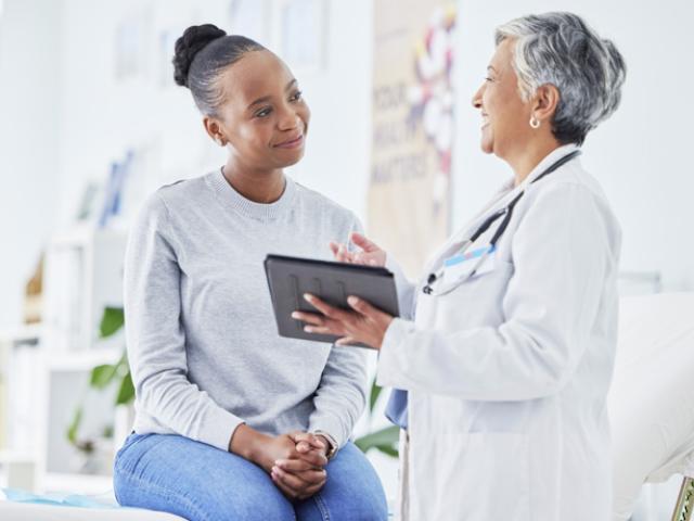 Mujer joven en República Dominicana asistiendo a una consulta ginecológica para informarse sobre la prevención y los síntomas del cáncer de cuello uterino.  