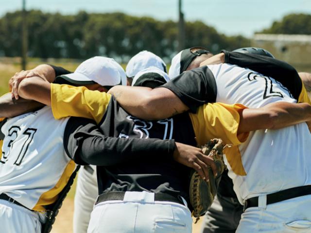 Grupo de personas tras jugar al beísbol, ejemplo de deporte y relaciones sociales como hábitos saludables. 