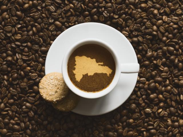 Taza de café junto a un mapa de República Dominicana, reflejo de los beneficios del café para el bienestar y la salud.