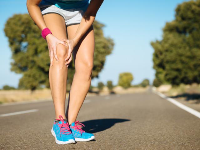 Imagen de deportista con dolor en las rodillas al doblarlas.