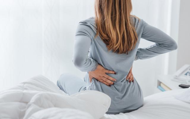 Mujer con dolores de espalda y cáncer.