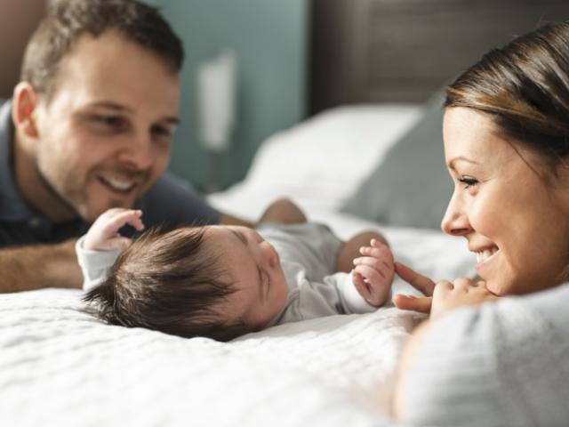 Padres durmiendo a su bebé